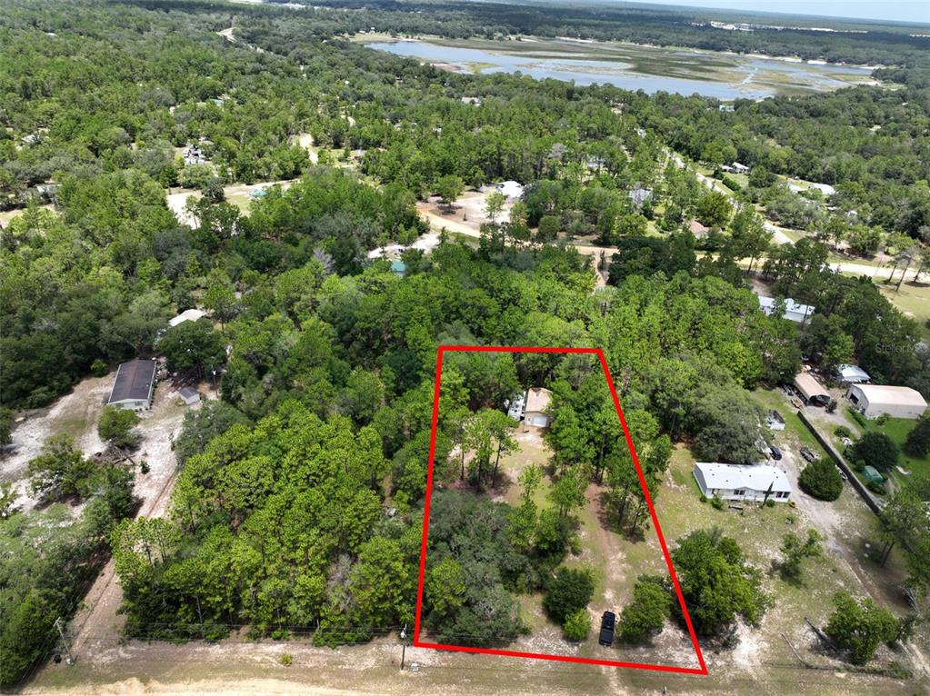 An aerial view shows a house situated on a wooded lot outlined in red — 5620 LASSEN STREET, KEYSTONE HEIGHTS, FL