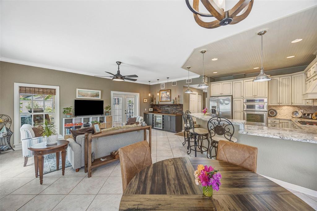 A living room with wood-look flooring, a blue area rug, and brown leather furniture — 852 35TH AVENUE N, ST PETERSBURG, FL