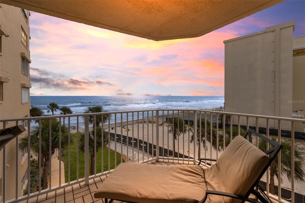 A living room features a white sectional sofa, wood flooring, and a balcony overlooking the ocean — 3145 S ATLANTIC AVENUE UNIT 405, DAYTONA BEACH SHORES, FL