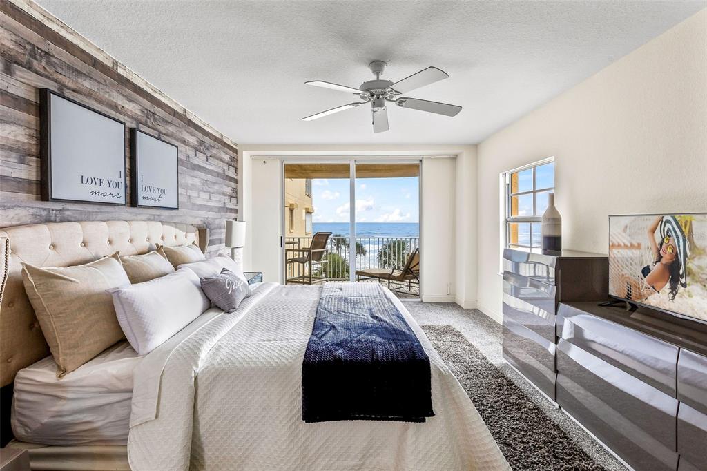 A living room with a white sectional sofa, wooden coffee table, and oceanfront balcony access — 3145 S ATLANTIC AVENUE UNIT 405, DAYTONA BEACH SHORES, FL