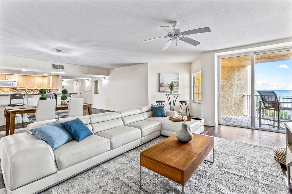 A balcony with tile flooring features a lounge chair, a small table, and two chairs — 3145 S ATLANTIC AVENUE UNIT 405, DAYTONA BEACH SHORES, FL