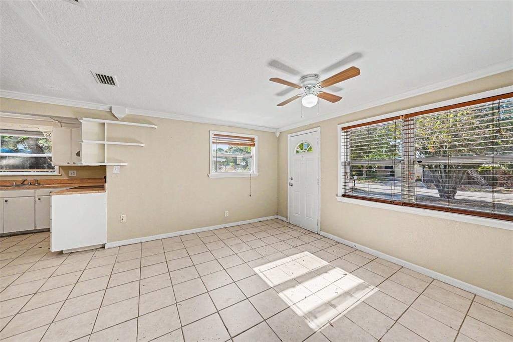 A kitchen and dining area with beige walls, tile flooring, and a ceiling fan — 10118 114TH TERRACE, LARGO, FL