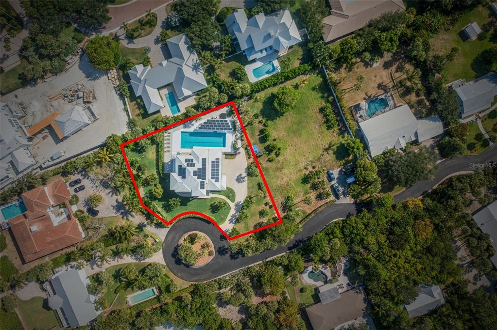 An aerial view shows a house with a swimming pool and solar panels on the roof — 2275 GENESEA LANE, VERO BEACH, FL