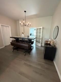 A dining area features a dark wood table with benches, a chandelier, and wood flooring — 1003 NE 2ND STREET, MULBERRY, FL