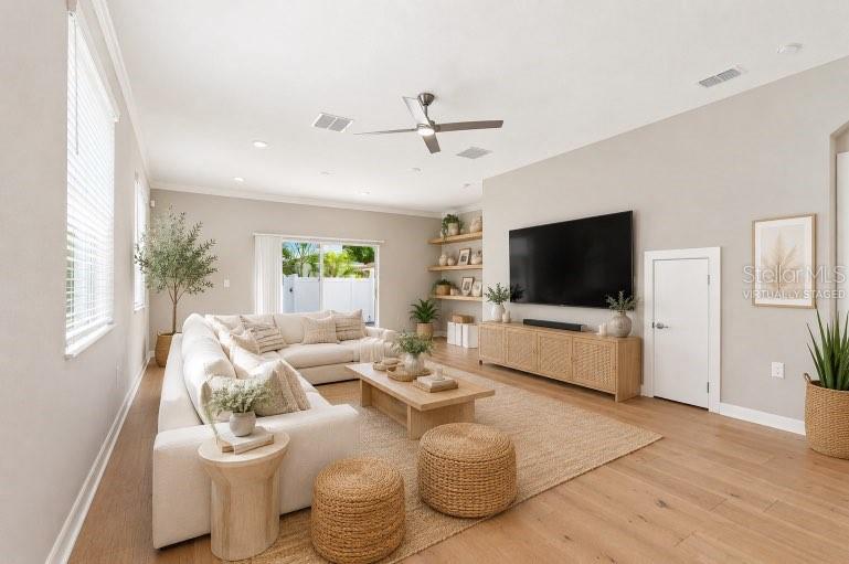 A modern kitchen features white cabinets, stainless steel appliances, light wood flooring, and a pantry — 2704 W GRAY STREET UNIT A, TAMPA, FL