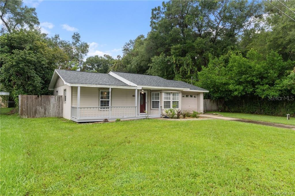 A single-story house with light-colored siding, a front porch, and a driveway on a lawn — 6094 E PENROSE STREET, INVERNESS, FL