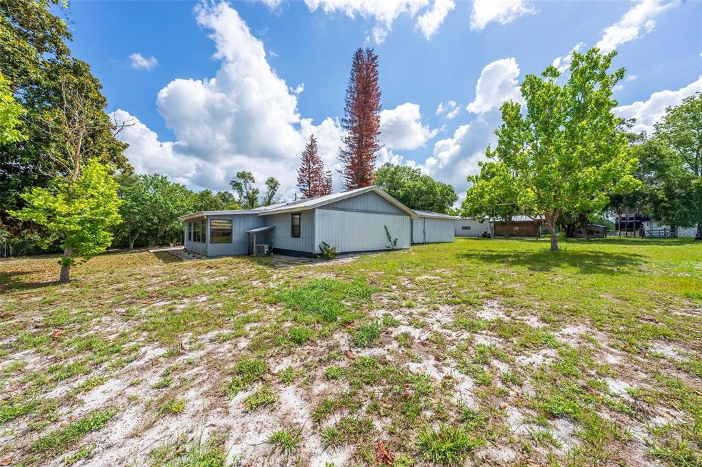 A single-story house with light-colored siding sits on a large, grassy, partially sandy lot — 3480 ONDICH ROAD, APOPKA, FL