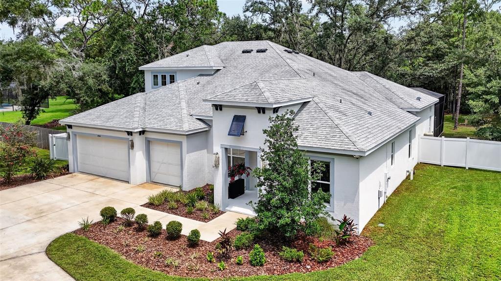 An aerial view of a white, two-story house with a gray shingled roof and garage — 2304 CLEMENT ROAD, LUTZ, FL