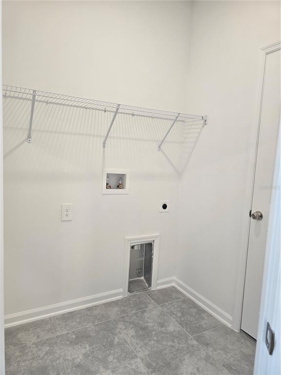 A laundry room with gray tile flooring, a wire shelf, and washer and dryer hookups — 1767 FOREMAN ROAD, EAGLE LAKE, FL