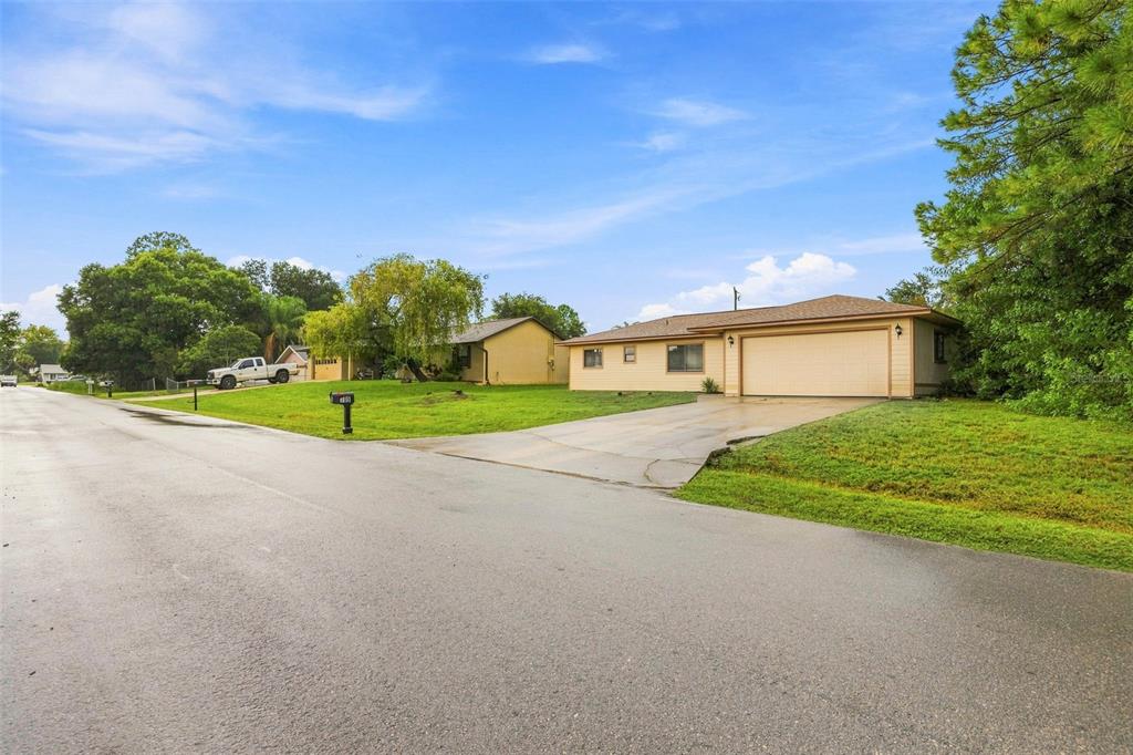 A single-story house with a tan exterior, a two-car garage, and a concrete driveway — 709 CUXHAVEN STREET NW, PALM BAY, FL