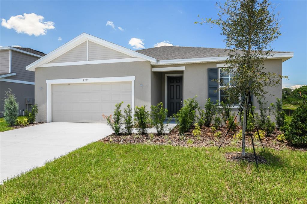 A bedroom features gray walls, a bed with white bedding, and a window with curtains — 1269 DAISY HILL AVENUE, DUNDEE, FL