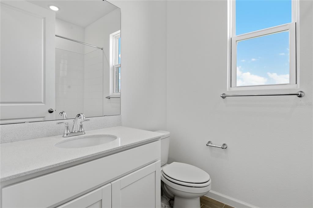 A modern kitchen features white cabinets, a central island with bar seating, and stainless appliances — 1269 DAISY HILL AVENUE, DUNDEE, FL