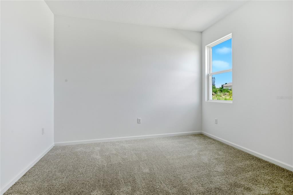 A kitchen features white cabinets, stainless steel appliances, and a black electric range — 1269 DAISY HILL AVENUE, DUNDEE, FL