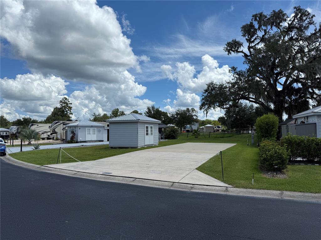 A concrete pad sits in front of a small shed in a residential park — 10264 NE 28TH LOOP, SILVER SPRINGS, FL