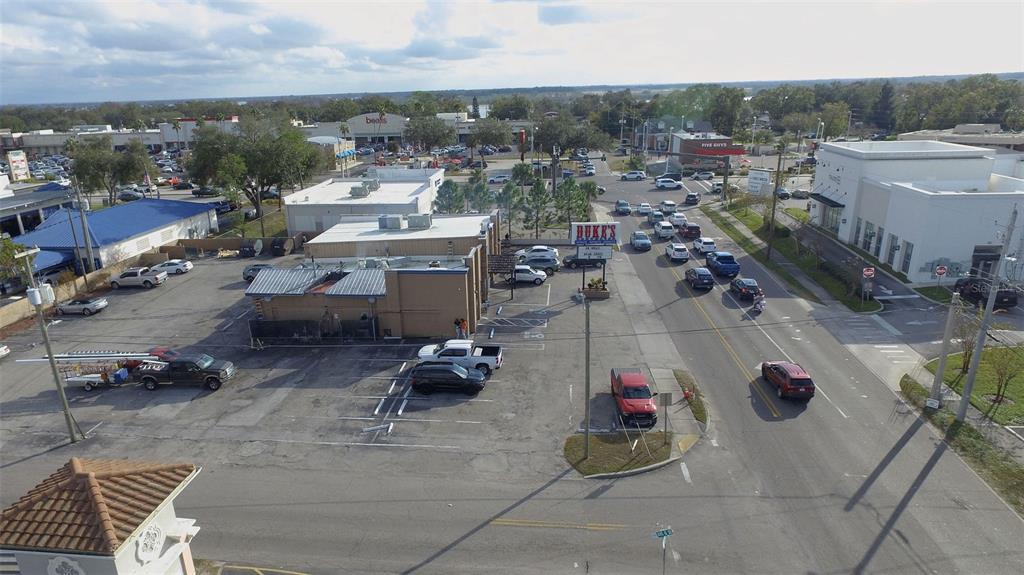 An aerial view shows a commercial parking lot, a restaurant building, and a busy road — 1708 6TH STREET SE, WINTER HAVEN, FL