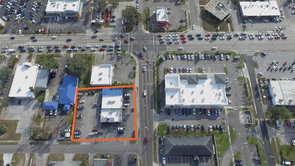 An aerial view shows a commercial property outlined in orange situated along a busy road — 1708 6TH STREET SE, WINTER HAVEN, FL