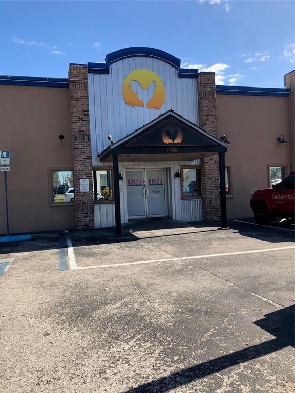 The exterior of a commercial building features a central entrance with a rooster logo — 1708 6TH STREET SE, WINTER HAVEN, FL