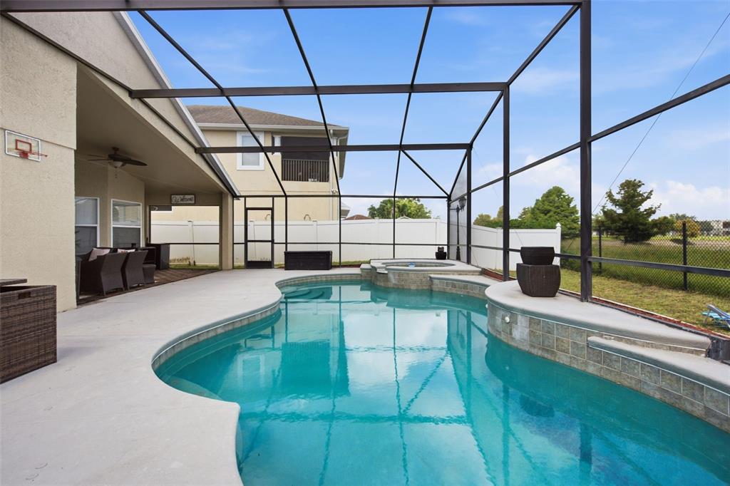 A screened-in patio features a swimming pool with an attached spa and concrete decking — 6539 CHERRY GROVE CIRCLE, ORLANDO, FL