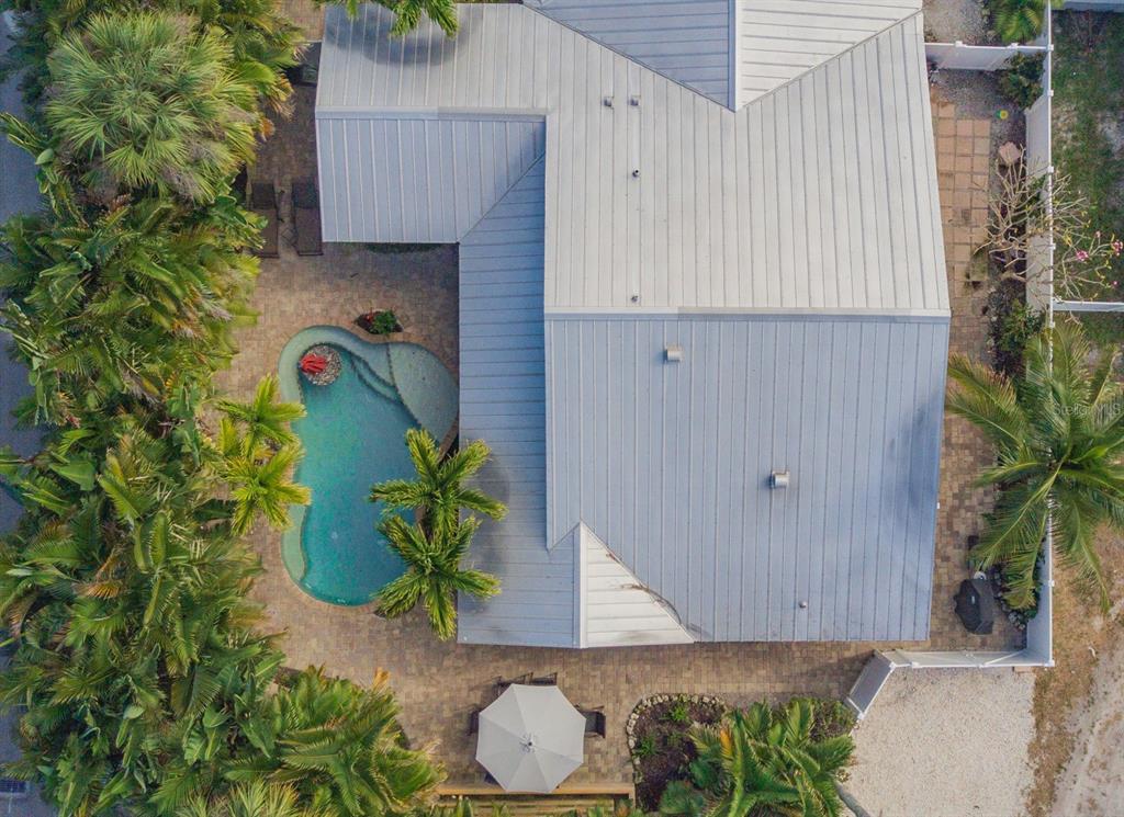 An aerial view of a house with a metal roof, a pool, and surrounding palm trees — 201 54TH STREET, HOLMES BEACH, FL