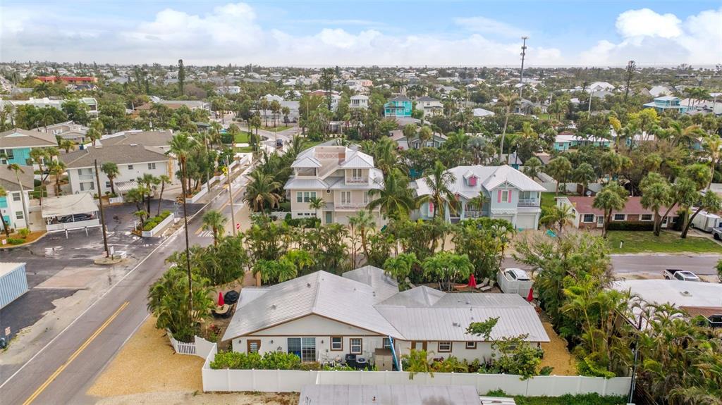 An aerial view shows a single-story house with a metal roof and a white fence — 201 54TH STREET, HOLMES BEACH, FL