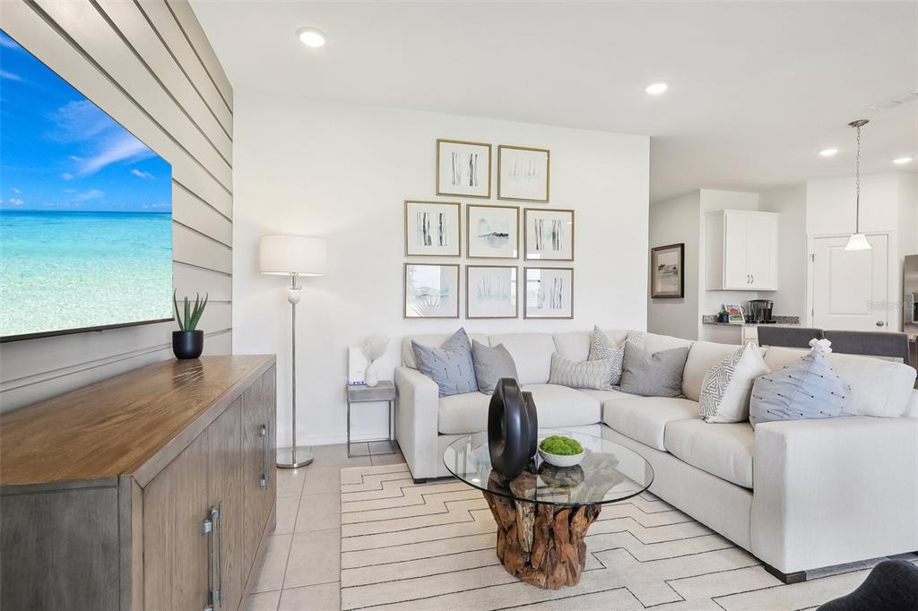 A living room features a sectional sofa, a wood-based coffee table, and a wall-mounted television — 5812 CLIFFBOW LOOP, LEESBURG, FL