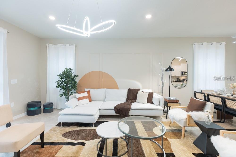 A modern living room features a white sectional sofa, patterned area rug, and geometric lighting — 7215 OAKMOSS LOOP, DAVENPORT, FL