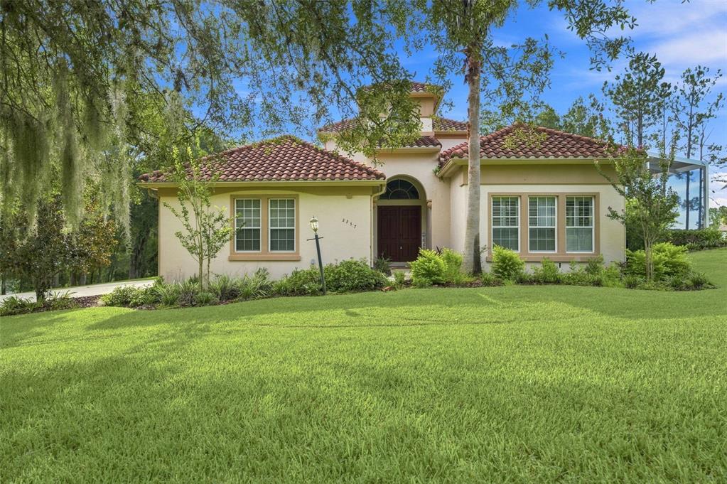 A single-story house with a tile roof, arched entryway, and a large front lawn — 2257 N HICKORY GLEN POINT, HERNANDO, FL