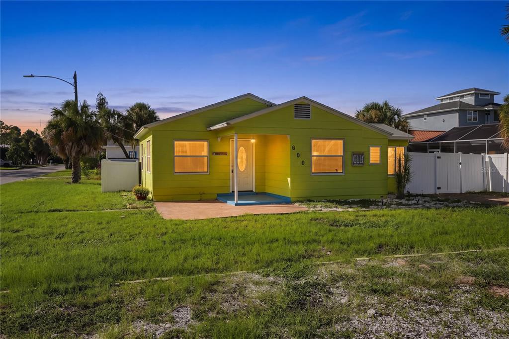 A lime green, single-story house with a front porch and a white fence — 600 79TH AVENUE, ST PETE BEACH, FL