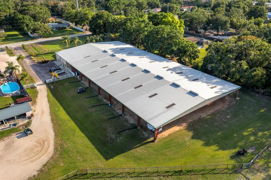 An aerial view shows a large metal warehouse building with a long covered open-air side — 7705 GARDNER ROAD, TAMPA, FL