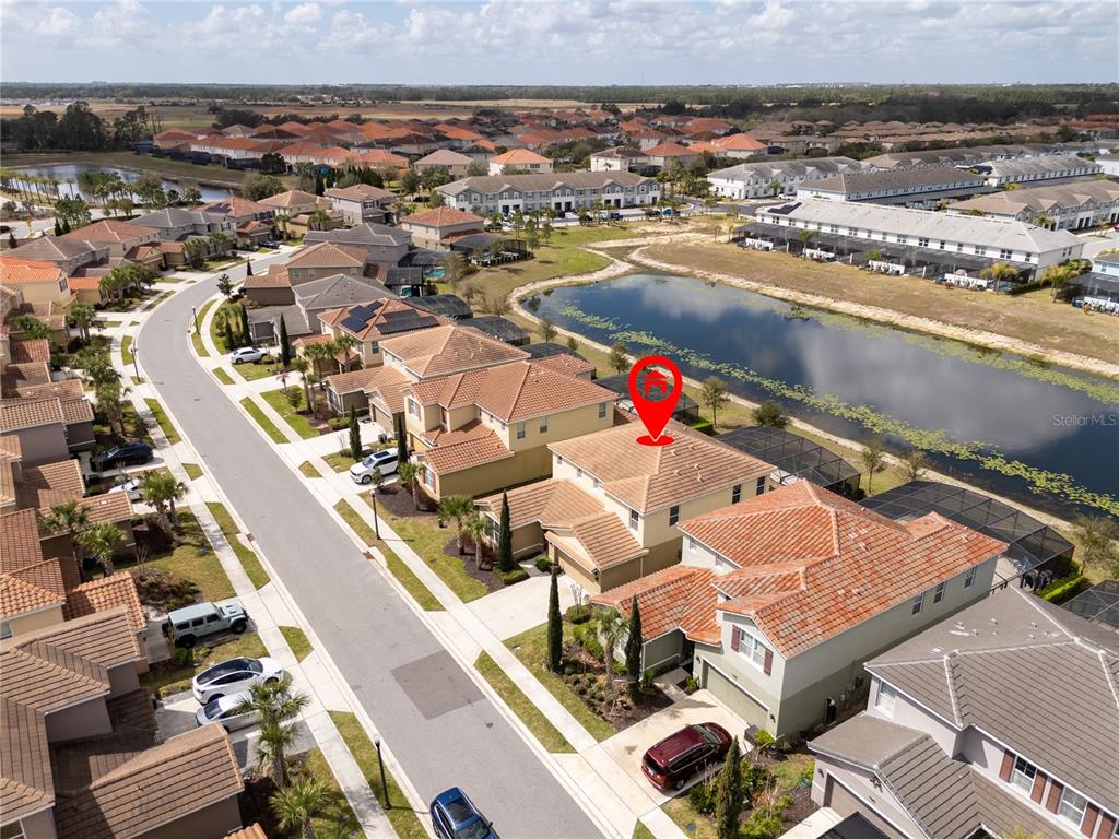 An aerial view shows a two-story suburban house with a red tile roof — 7560 OAKMOSS LOOP, DAVENPORT, FL