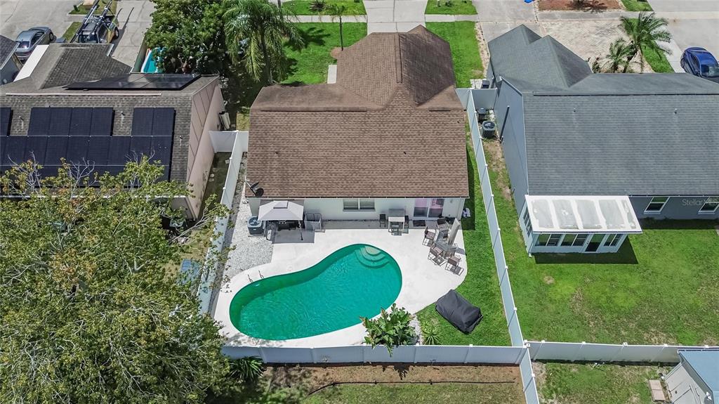 An aerial view shows a house with a brown roof, a pool, and a white fence — 9063 DIXIANA VILLA CIRCLE, TAMPA, FL