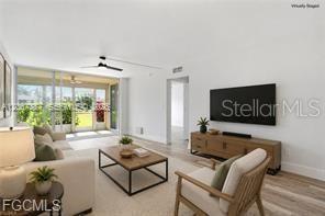 A swimming pool sits in front of a yellow apartment building with palm trees — 1085 FOREST LAKES DRIVE UNIT 102, NAPLES, FL