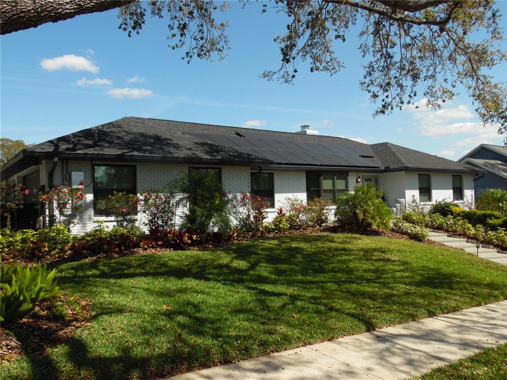 A single-story white brick house with a dark shingled roof and solar panels — 2709 FAIRWAY VIEW DRIVE, VALRICO, FL