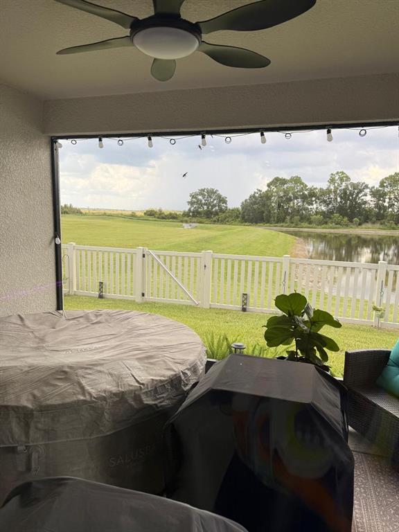 A covered patio features a hot tub, outdoor seating, and a view of a grassy lawn — 5508 MADDIE DRIVE, HAINES CITY, FL