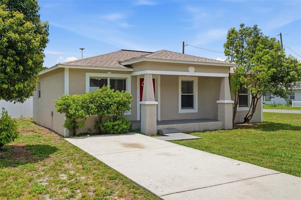 A tan single-story house with a front porch, concrete driveway, and green landscaping — 5331 5TH STREET, ZEPHYRHILLS, FL