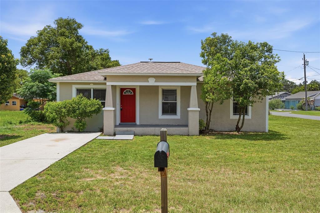A single-story house with a red front door, a covered porch, and a concrete driveway — 5331 5TH STREET, ZEPHYRHILLS, FL