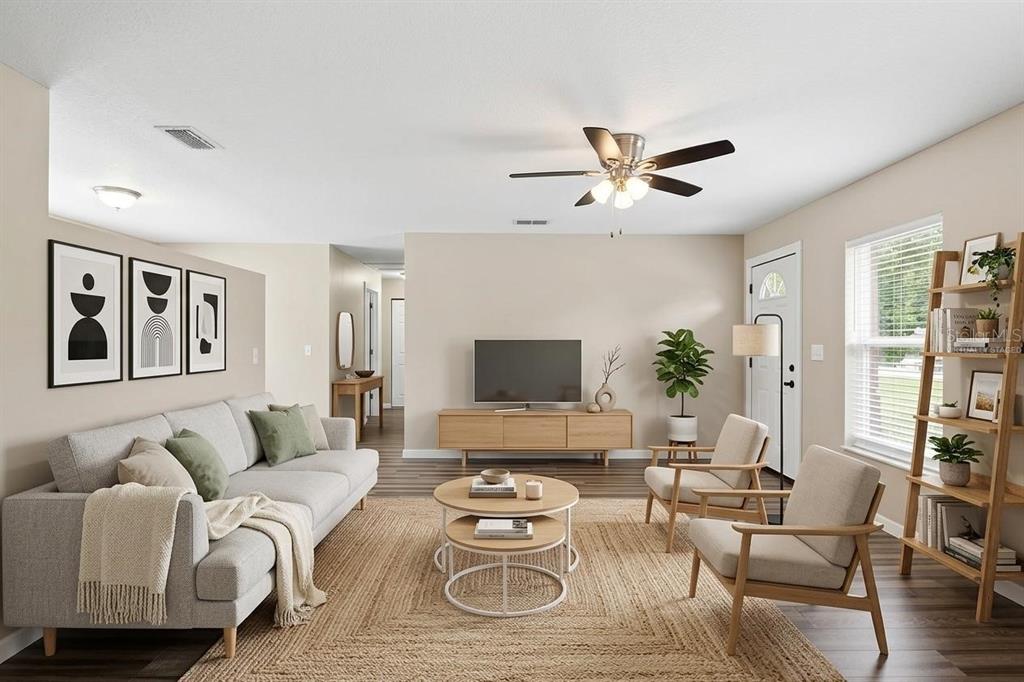 A living room features a gray sofa, two armchairs, a coffee table, and a television console — 5331 5TH STREET, ZEPHYRHILLS, FL