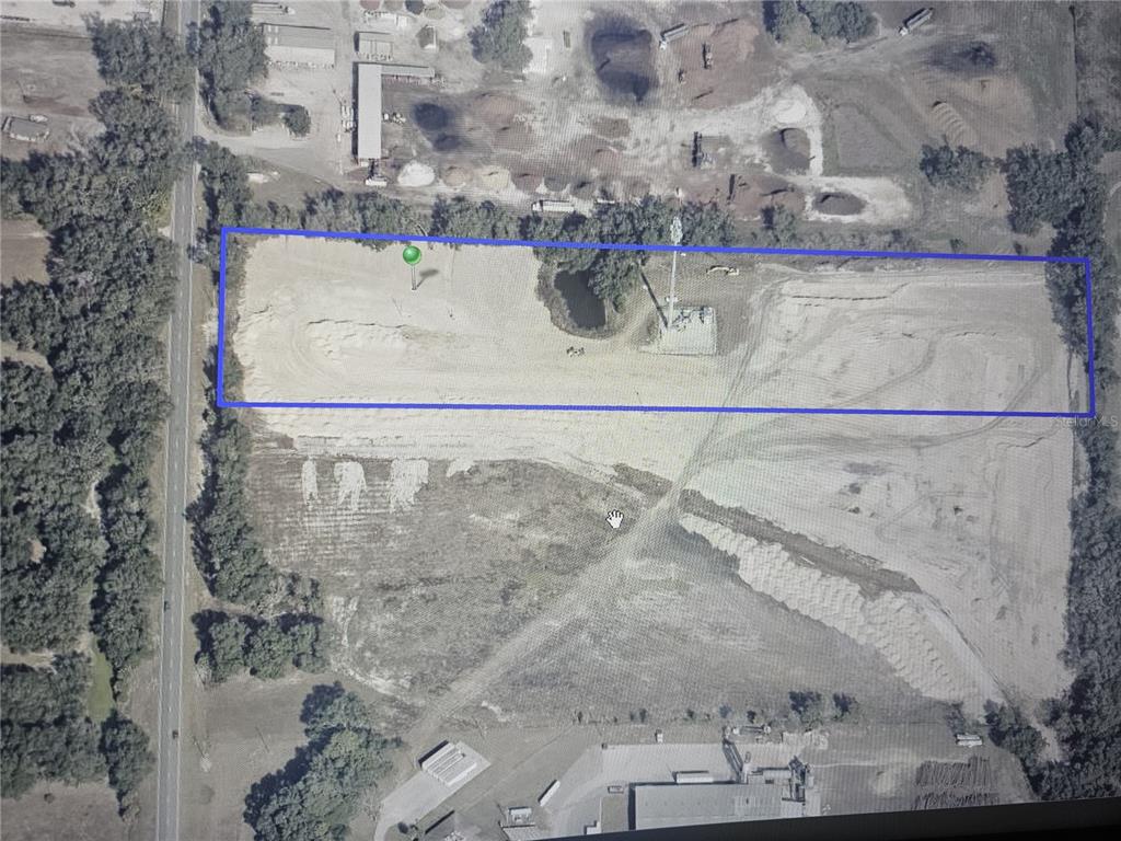 An aerial view shows a rectangular plot of land outlined in blue with cleared soil — 26630 COUNTY ROAD 33, OKAHUMPKA, FL