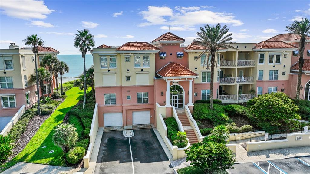 An exterior view of a multi-story, peach-colored residential building with a tiled roof and balconies — 230 N SERENATA DRIVE UNIT 711, PONTE VEDRA BEACH, FL