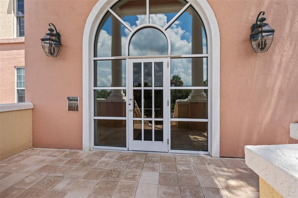 An arched glass door with sidelights is centered on a tiled outdoor patio — 230 N SERENATA DRIVE UNIT 711, PONTE VEDRA BEACH, FL