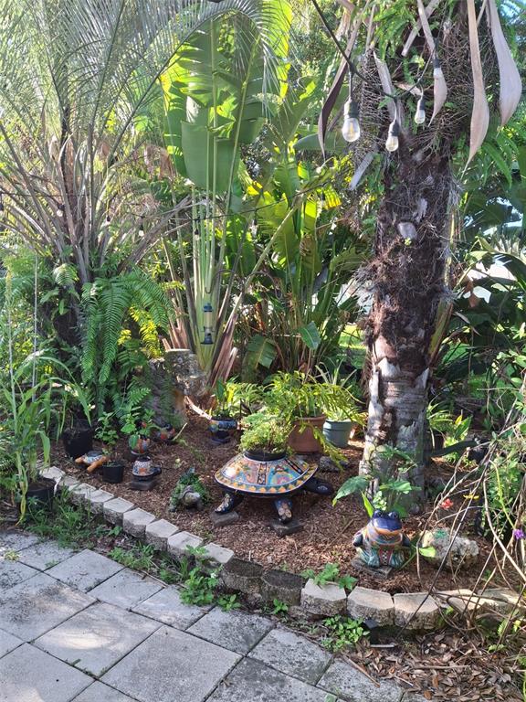 A garden area features a paved patio, a large palm tree, and several decorative turtle planters — 135 ENGLEWOOD HEIGHTS ROAD, ENGLEWOOD, FL