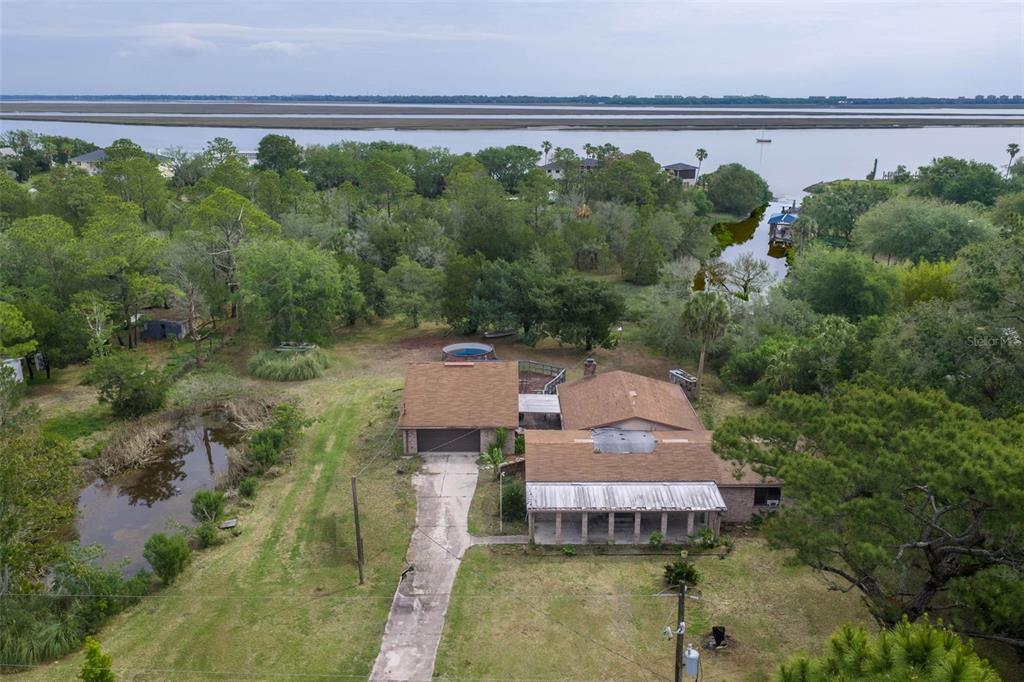 An aerial view shows a house with a brown roof, a driveway, and a pool — 16229 SHELLCRACKER ROAD, JACKSONVILLE, FL