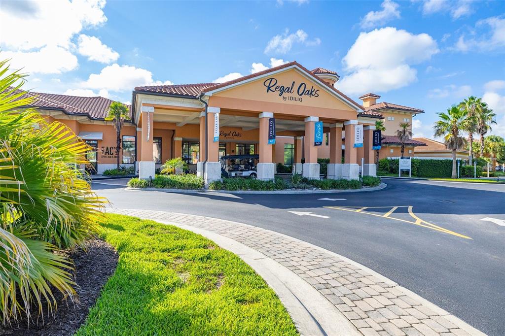 The exterior of the Regal Oaks clubhouse features a covered entrance with a paved driveway — 2739 COUPE STREET, KISSIMMEE, FL