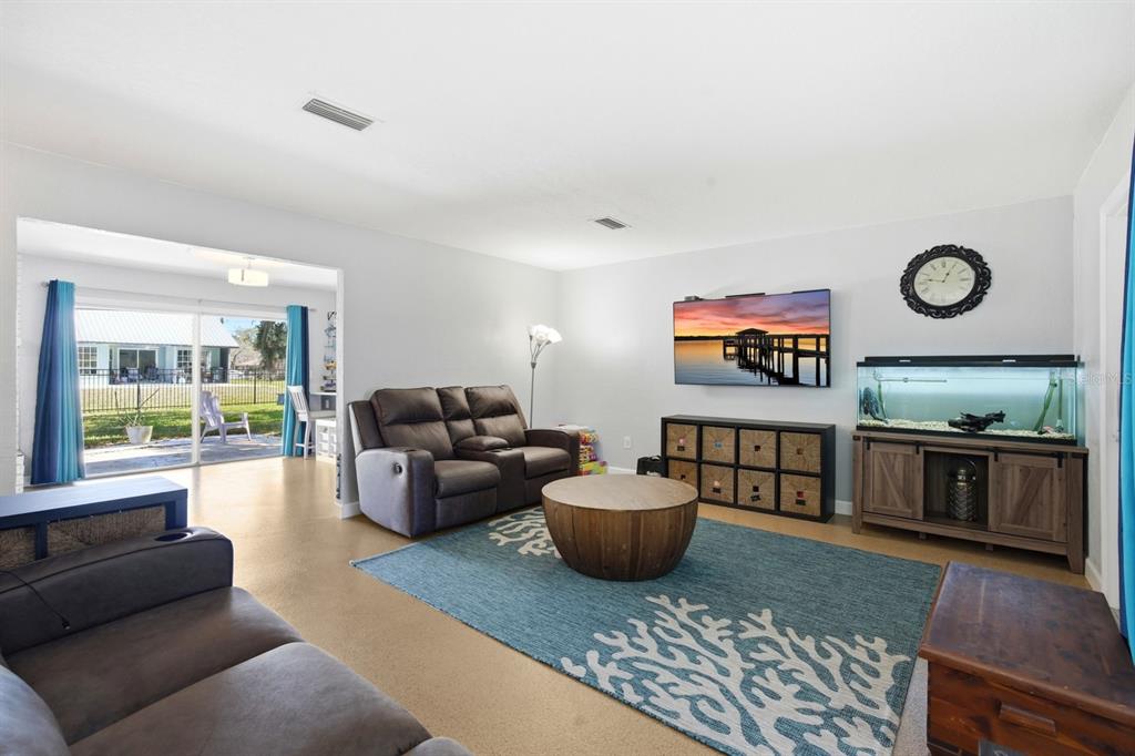 A living room with a brown sofa, blue area rug, television, and a large fish tank — 2329 LIME TREE, EDGEWATER, FL