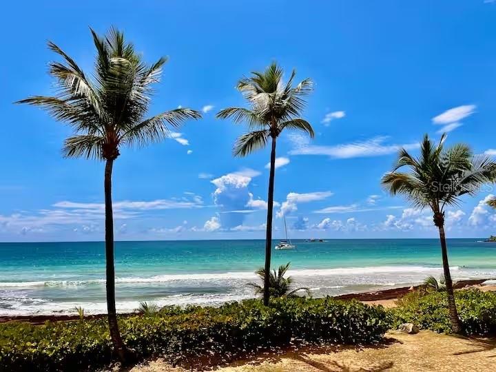 A modern kitchen features light wood cabinetry, white upper cabinets, white subway tile, and stainless appliances — DR BEACH VILLAGE UNIT 148, HUMACAO, PR