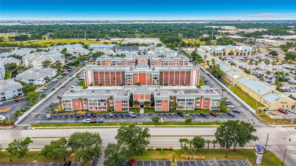 An open-concept kitchen with wood cabinets and granite countertops flows into a living area — 1900 68TH STREET N UNIT 301, ST PETERSBURG, FL