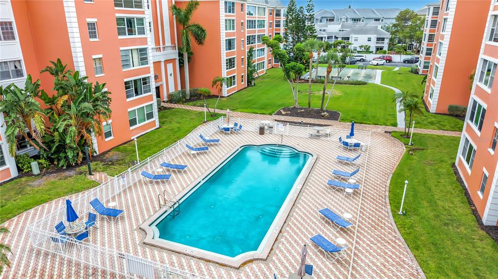 A kitchen with wood cabinets, granite countertops, and light flooring opens into a living area — 1900 68TH STREET N UNIT 301, ST PETERSBURG, FL