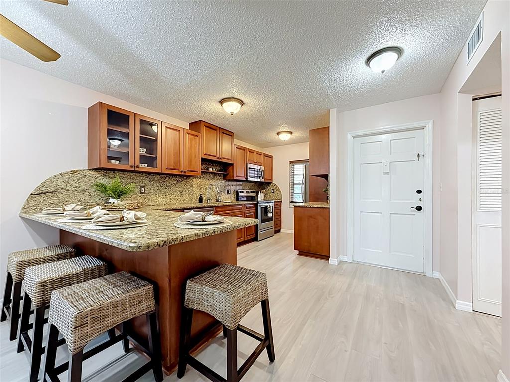 A kitchen with wood cabinets, granite countertops, and stainless steel appliances — 1900 68TH STREET N UNIT 301, ST PETERSBURG, FL