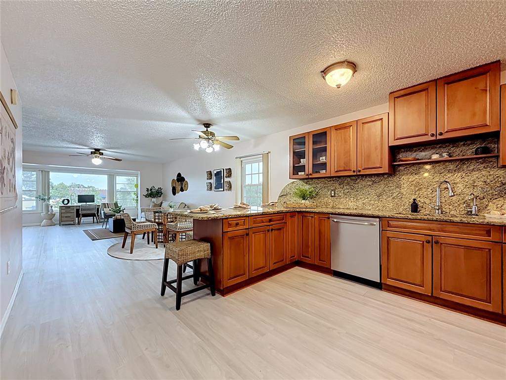 A kitchen area with wood cabinets, granite countertops, and a stainless steel refrigerator — 1900 68TH STREET N UNIT 301, ST PETERSBURG, FL