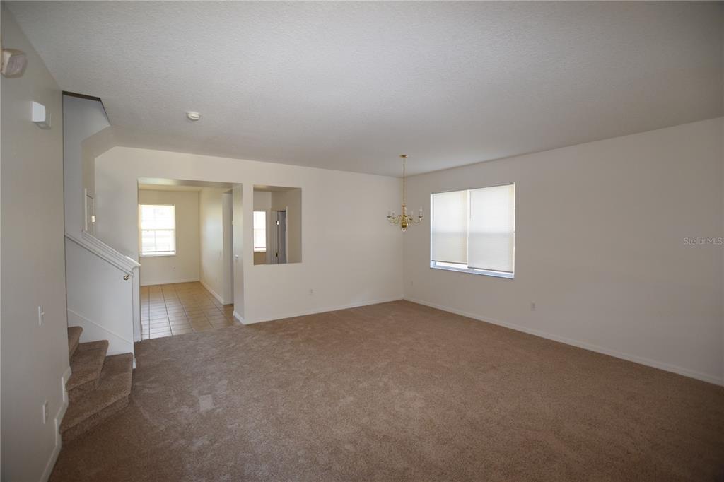 A living room features a large beige sectional sofa, a wooden coffee table, and tile flooring — 622 ALFANI STREET, DAVENPORT, FL